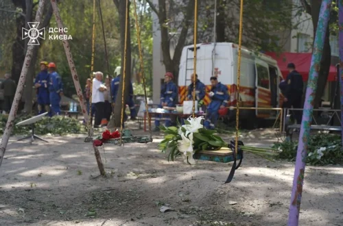 Кияни несуть квіти до знищеного росіянами будинку, де тривають пошукові роботи (фото)